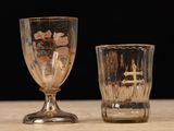 two wine glasses sitting on a table with a black background