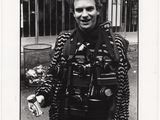 photographie en noir et blanc d'un homme vêtu d'une veste en cuir tenant une canette de soda