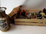 a wooden crate with a vase and other items in it