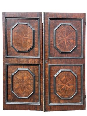 pair of antique wooden doors with carved panels on each side