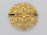 an image of a gold broochle with a flower design