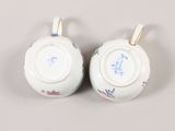 pair of porcelain teapots with floral designs on them