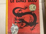 un vieux livre posé sur une table, à côté d'un vase