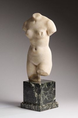 statue en marbre représentant un torse féminin, posée sur un socle en marbre