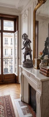 une cheminée au milieu d'une pièce, avec un miroir accroché au mur
