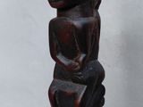 an image of a wooden sculpture of a monkey sitting on top of a rock