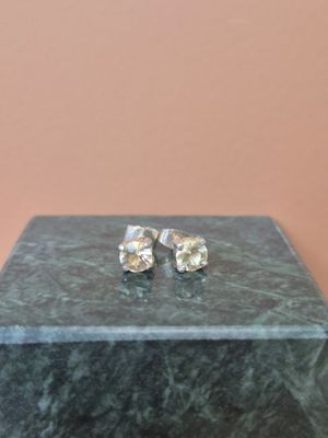 une paire de boucles d'oreilles en diamant posée sur un coffret en marbre