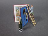 a small figurine of a man standing on a ladder next to a book