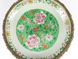 une image représentant une assiette verte et rose ornée de fleurs