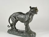 a bronze statue of a lion on a rock on a white background