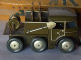 a green toy truck with a gun on top of it