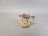 a small blue and white pitcher on a white surface