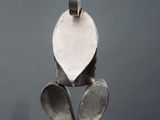 a metal sculpture of a leaf on a white pedestal