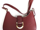 un gros plan sur un sac à main rouge orné d'un anneau doré