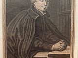 an old picture of a man sitting at a desk with a book