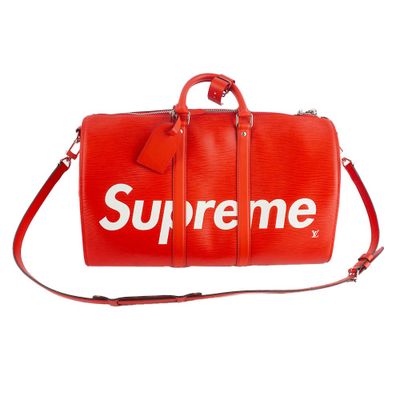 a red supreme duffel bag on a white background