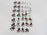 many figurines of people riding horses on a white surface
