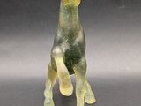 a glass figurine of a giraffe on a table