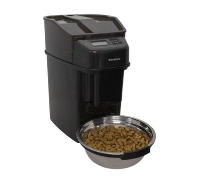 a dog bowl with food inside of it next to a food dispenser