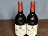 two bottles of wine sitting on a wooden table