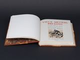 un livre ouvert posé sur une table, devant un fond noir