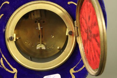 une horloge bleue et dorée avec un cadran rouge