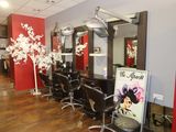a picture of a hair salon with chairs and mirrors
