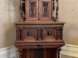 une étagère en bois ornée de sculptures, dans une pièce