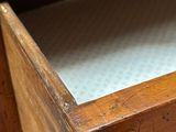a close up of a wooden drawer with a paper in it