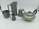 de nombreux modèles différents de théières et de tasses en argent sur la table