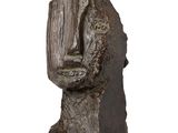 sculpture représentant la tête d'un homme portant un gant de baseball, posée sur un socle en bois