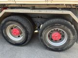 a large truck with two big tires on it ' s flatbed