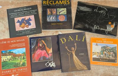 Plusieurs livres sont posés sur une table au plateau en bois.