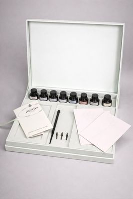 une boîte contenant un stylo, du papier et des flacons d'encre