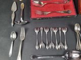a lot of silver spoons and forks on the table