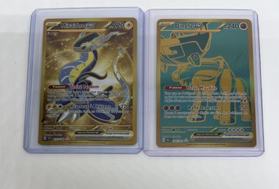 two pokemon cards are sitting side by side on a table