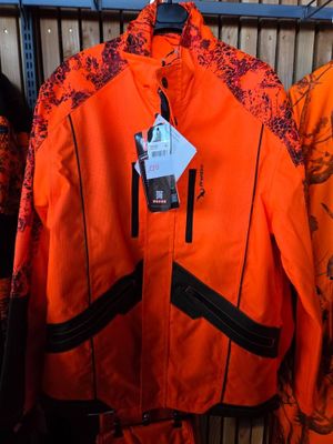 an orange jacket hanging on a rack in a store