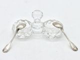 two silver spoons and a silver spoon on a white surface