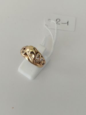 a close up of a gold ring on a white surface