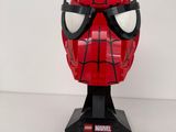un gros plan d'un masque de Spider-Man rouge sur une surface blanche