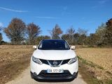 the front of a white nissan suv parked on a dirt road