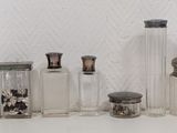 five glass bottles that are lined up on a shelf