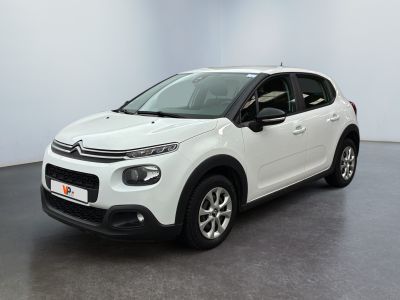 Une Citroën blanche est garée dans une pièce blanche