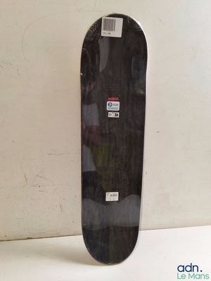 un skateboard noir posé sur une surface blanche