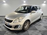 a silver suzuki swift is parked in a room with checkered floor