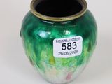 a green vase with a gold rim on a white surface
