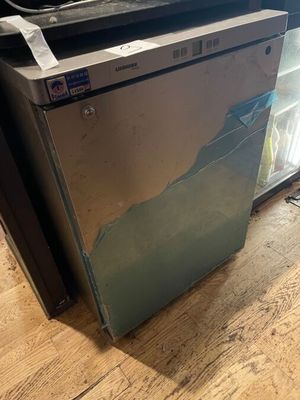 a broken refrigerator sitting on the floor in the kitchen