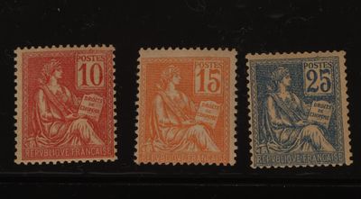 quatre timbres de couleurs différentes sur une surface noire avec un fond noir