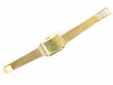a close up of a gold watch on a white surface