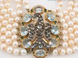 two strands of pearls and a broochle with blue and white stones